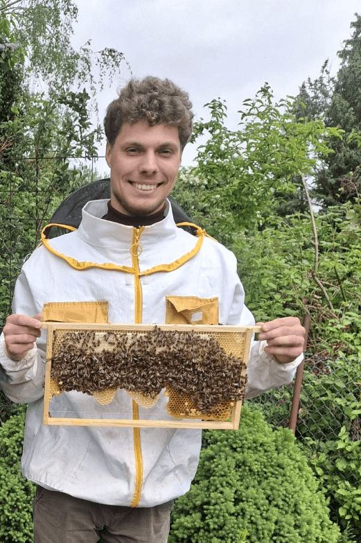 Imker Philipp Harde mit einer Wabe voller Bienen