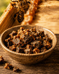 Schale mit Rohpropolis der Imkerei Harde, dahinter Bienen am Holzrahmen