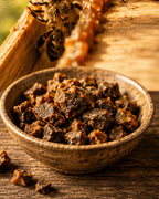 Schale mit Rohpropolis der Imkerei Harde, dahinter Bienen am Holzrahmen